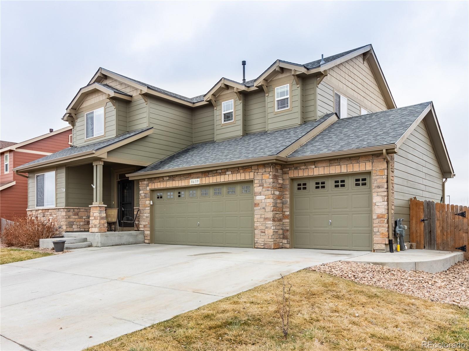 8639 Raspberry Drive Frederick, CO 80504 - Photo 3 of 30 a front view of a house with a yard and garage