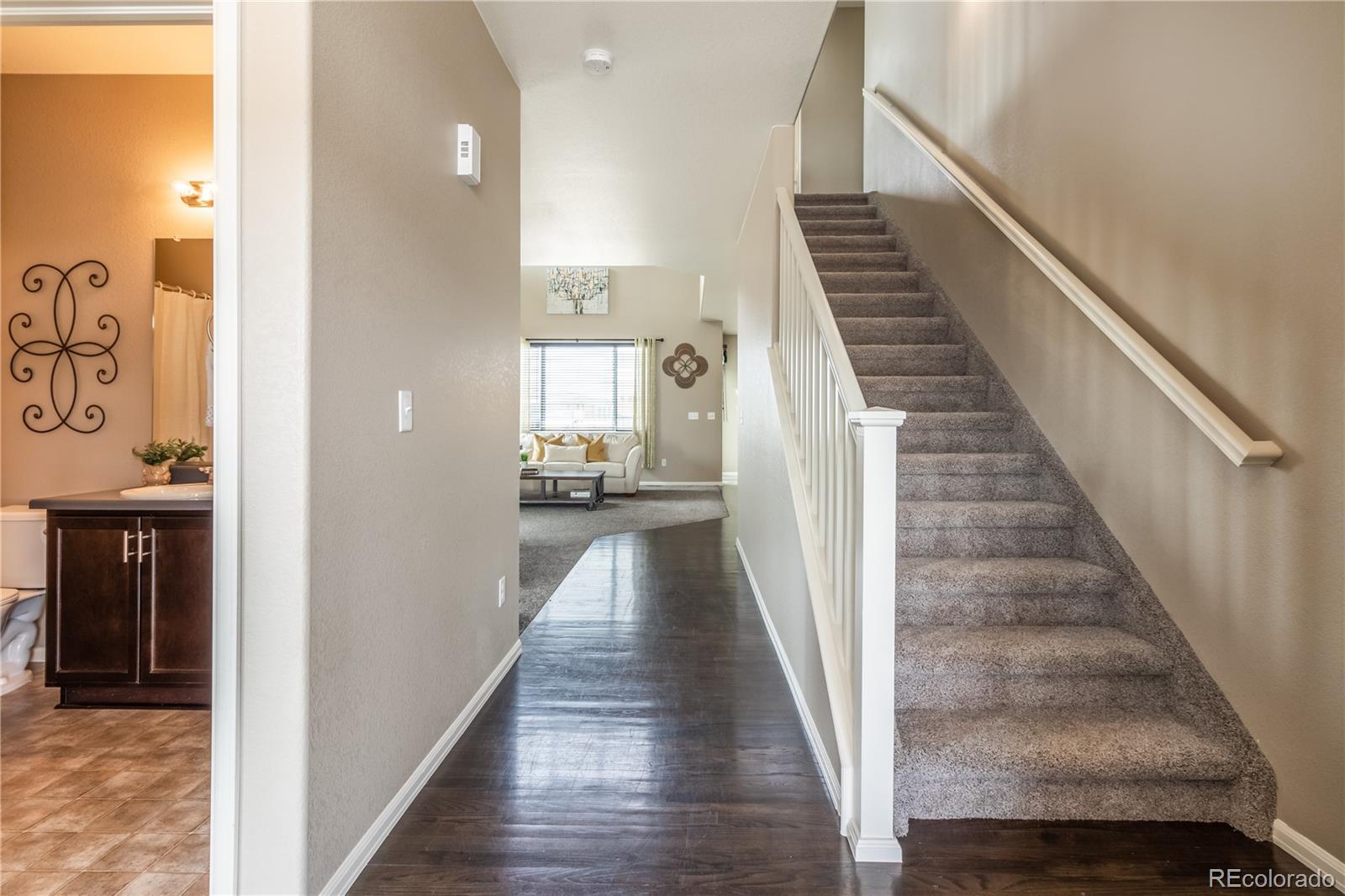 8639 Raspberry Drive Frederick, CO 80504 - Photo 6 of 30 a view of a hallway with wooden floor and staircase
