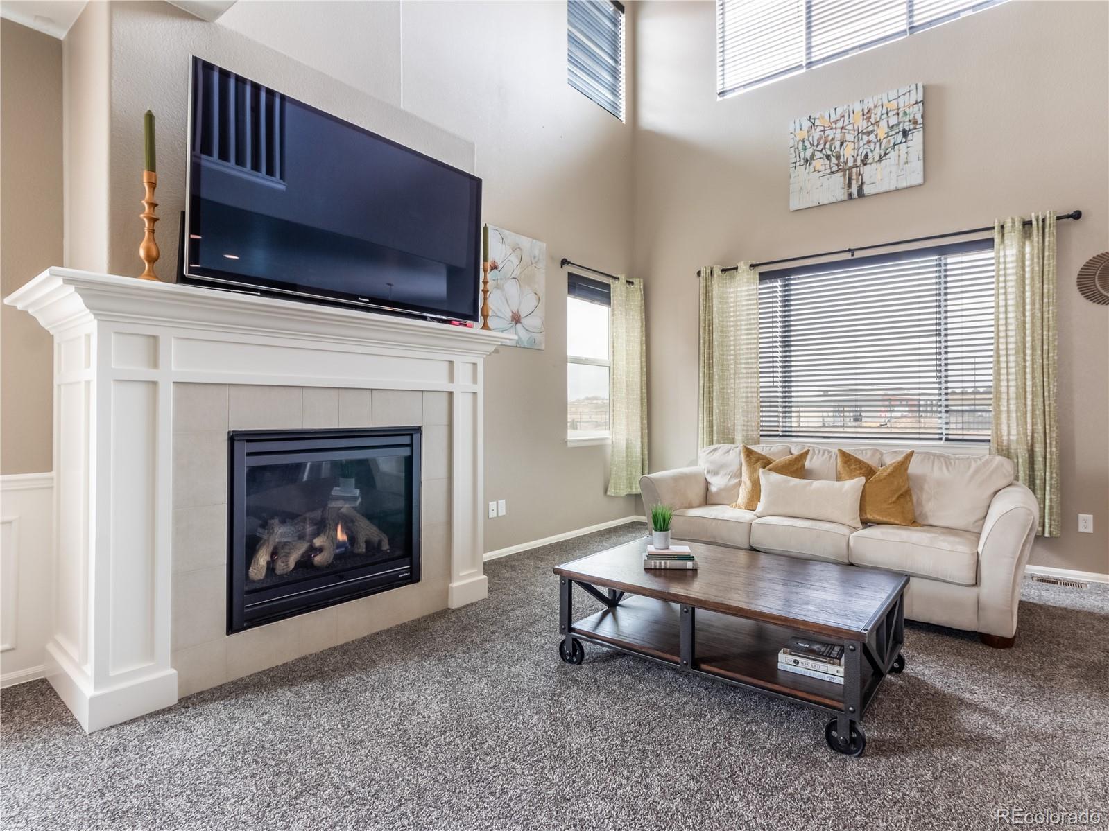 8639 Raspberry Drive Frederick, CO 80504 - Photo 10 of 30 a living room with furniture a flat screen tv and a fireplace