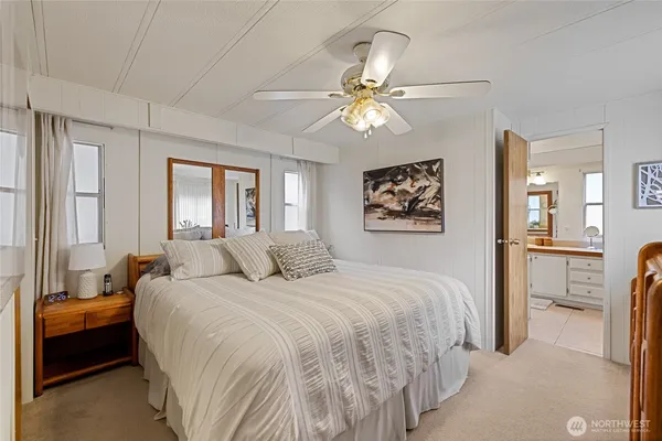 a bedroom with a large bed a flat tv screen and a chandelier