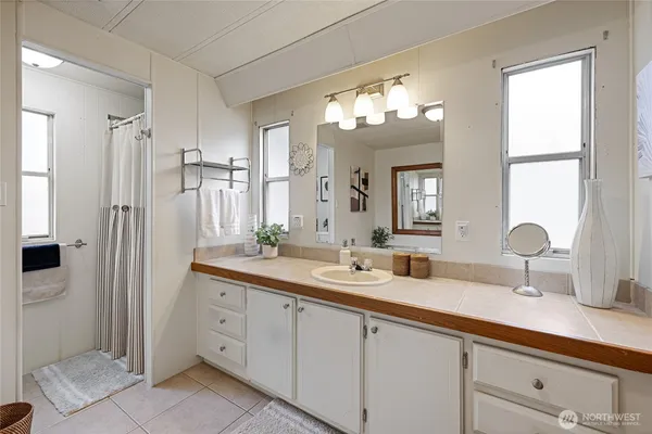 a bathroom with a tub sink and mirror