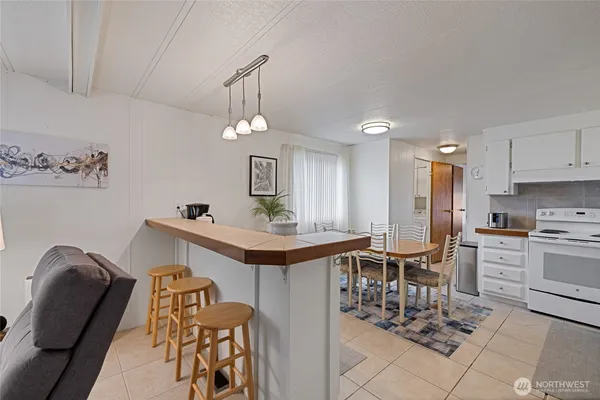 a living room with furniture a chandelier and kitchen view