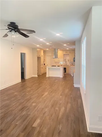 a view of a kitchen with kitchen island a sink wooden floor and appliances