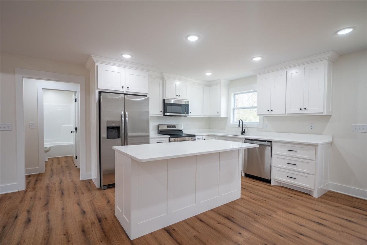 3987 Buffalo Road Summertown, TN 38483 - Photo 8 of 26 a kitchen with white cabinets and stainless steel appliances