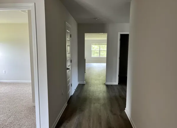 a view of a hallway with wooden floor and closet
