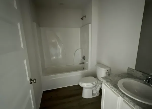 a white toilet sitting next to a bath tub