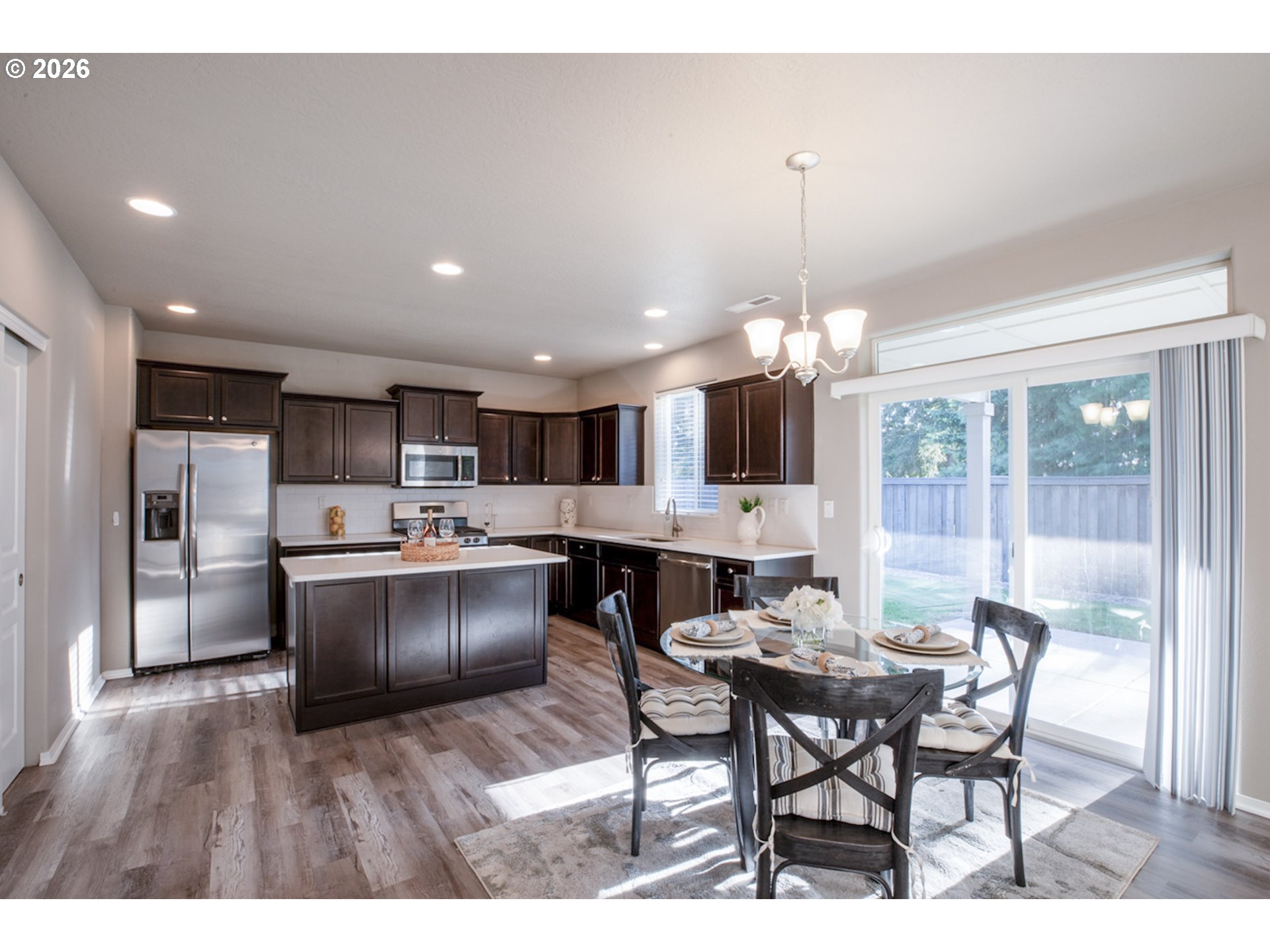 2952 Shelby Way Eugene, OR 97404 - Photo 4 of 25 a kitchen with stainless steel appliances kitchen island granite countertop a dining table chairs and a refrigerator