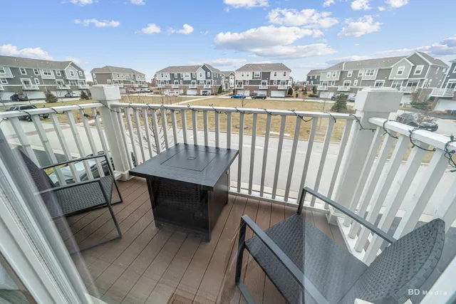 a view of a balcony with wooden chairs