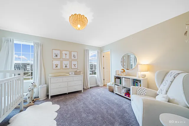 a living room with furniture and a baby crib