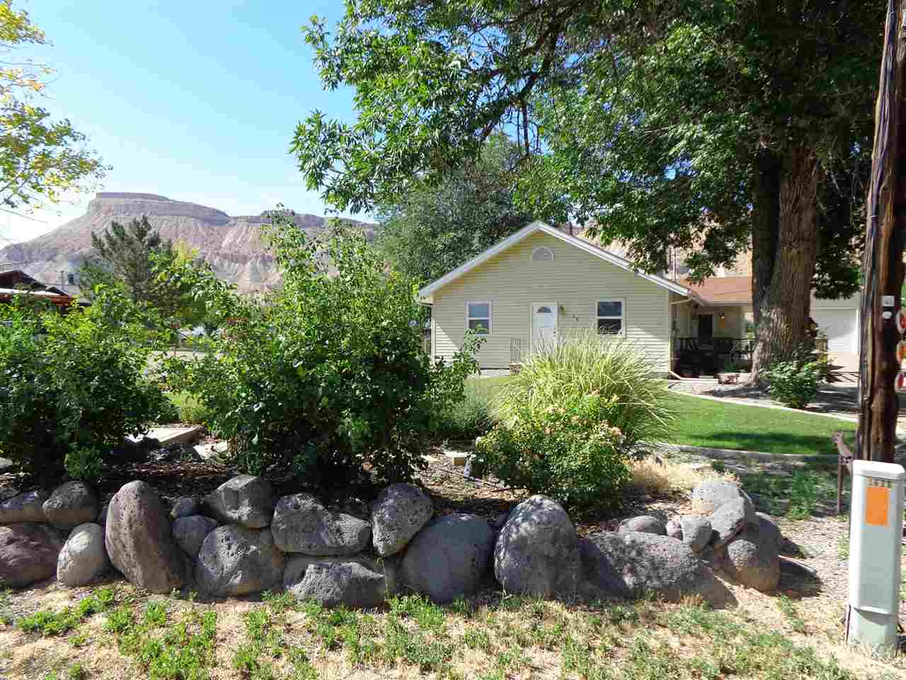 3628 G Road Palisade, CO 81526 - Photo 2 of 24 a front view of a house with a yard and a garden