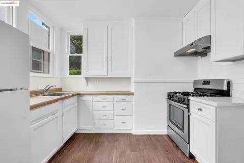 a kitchen with stainless steel appliances a stove a sink and white cabinets