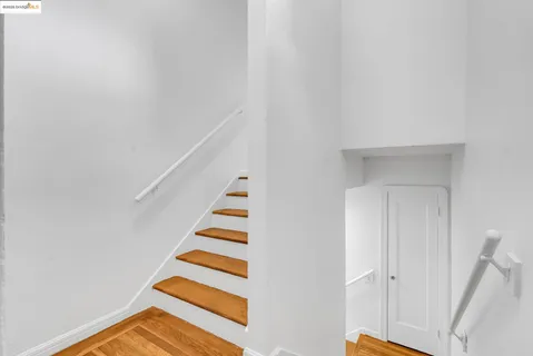 a view of a hallway with wooden floor and furniture