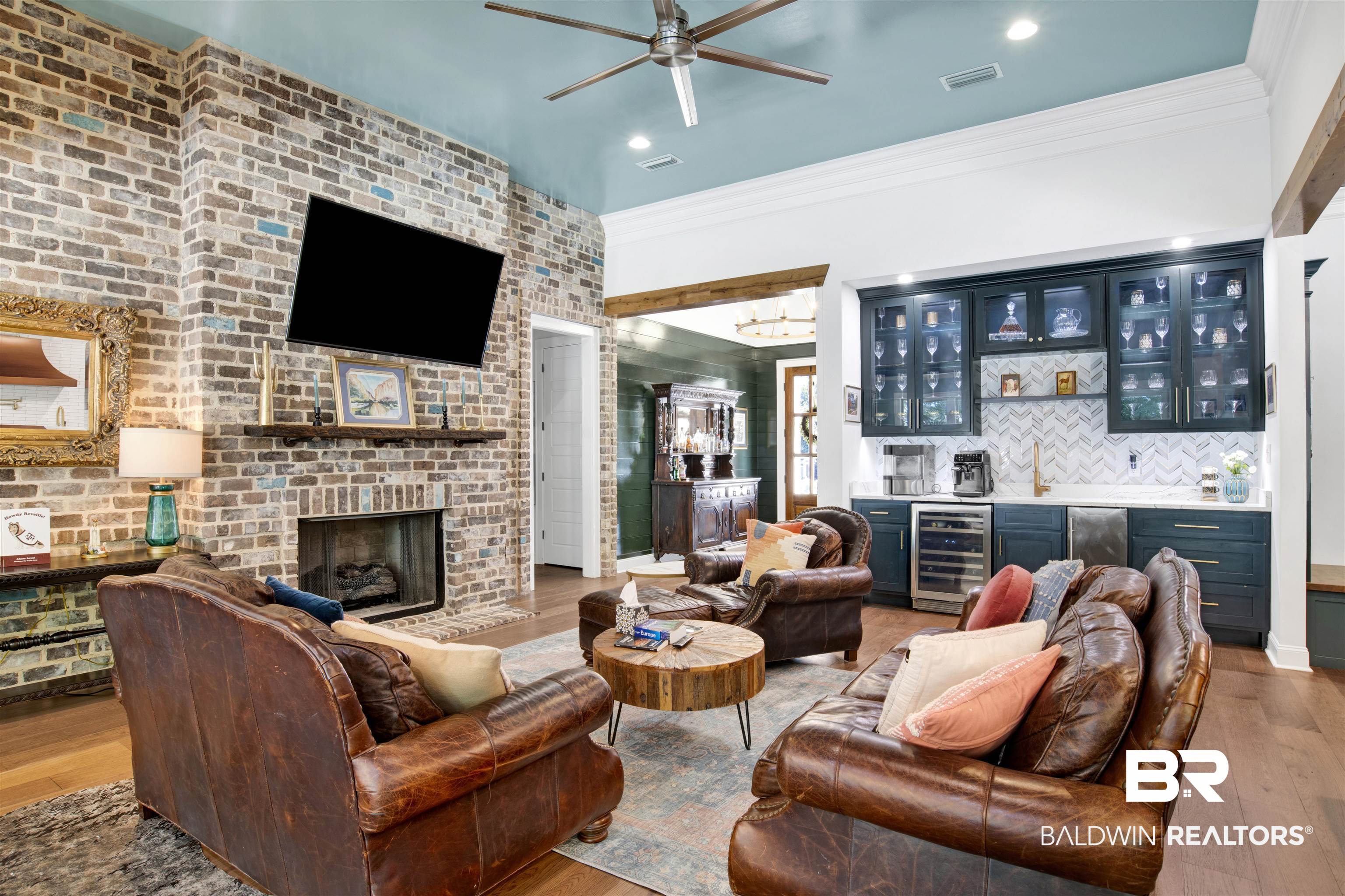 11116 Redfern Road Daphne, AL 36526 - Photo 18 of 46 Living room with light wood-style flooring, wine cooler, a fireplace, ornamental molding, and a chandelier