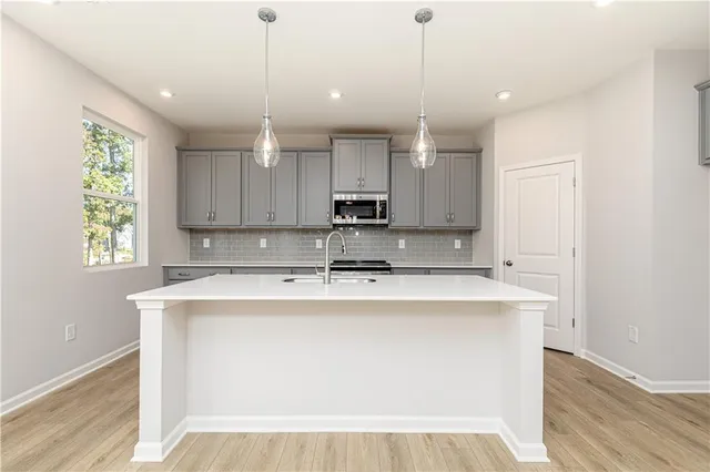 a kitchen with stainless steel appliances granite countertop white cabinets a sink and dishwasher