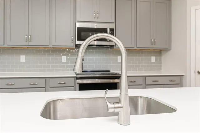 a kitchen with a sink chandelier and wooden floor