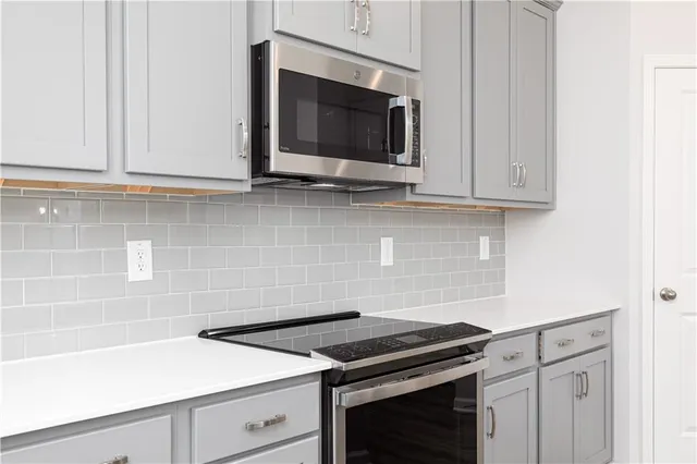 an empty room with windows and a fireplace