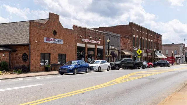 a view of a park with bench and a large tree