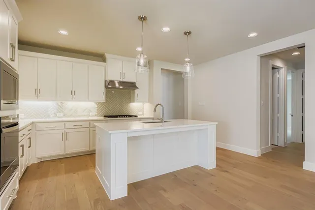 a kitchen with appliances a sink and cabinets