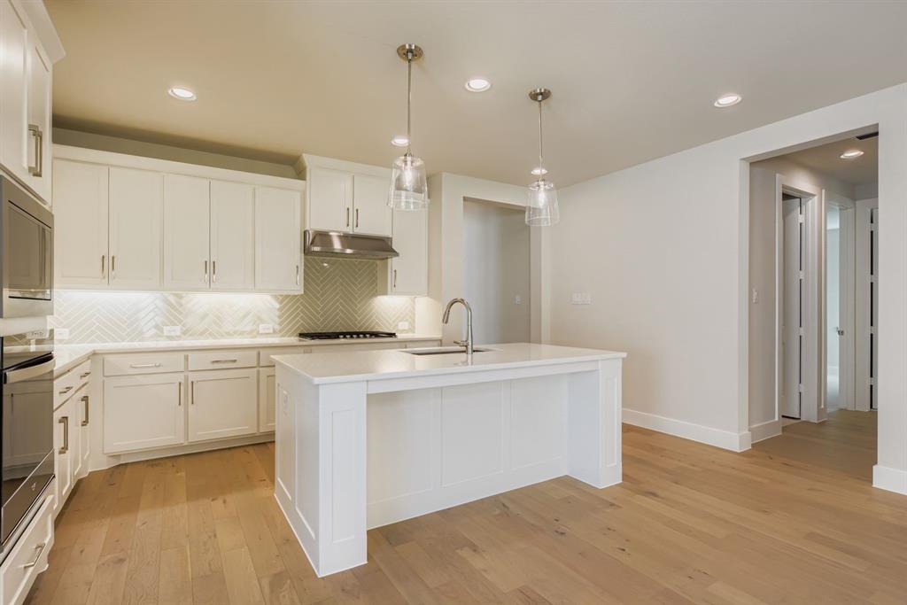 4123 Windy Point Court Oak Point, TX 75068 - Photo 9 of 29 a kitchen with kitchen island a sink stainless steel appliances and cabinets