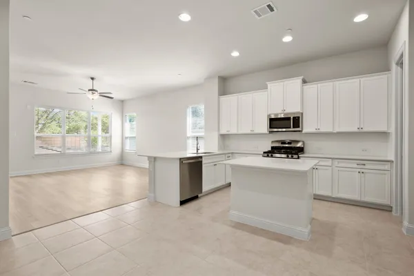 a kitchen with granite countertop white cabinets and white appliances