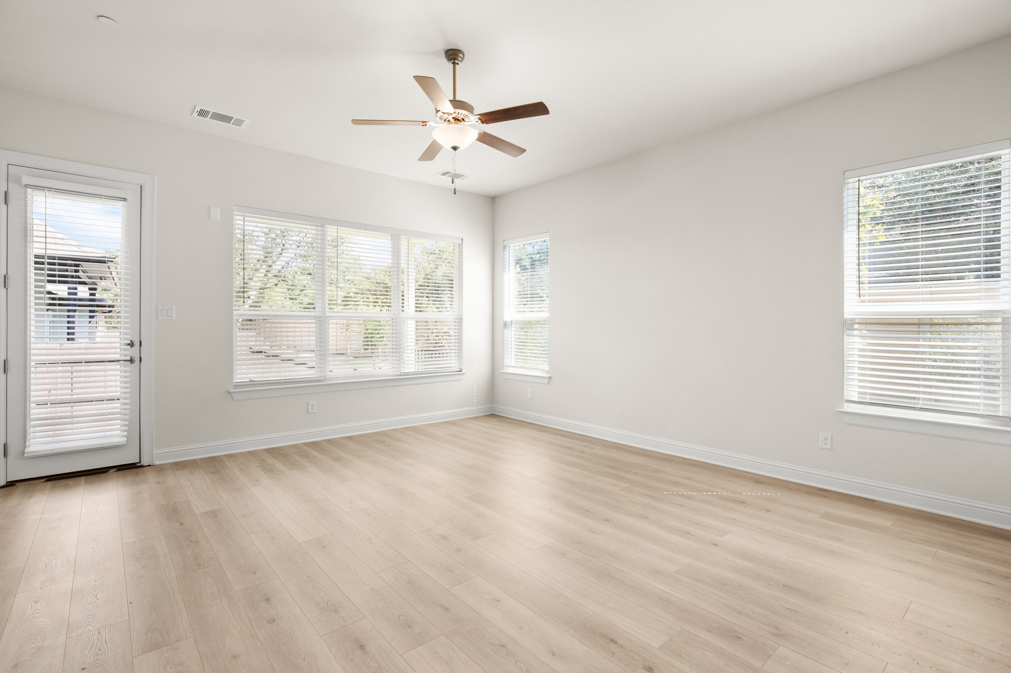 600 C-Bar Ranch Trail, Unit 144 Cedar Park, TX 78613 - Photo 3 of 17 an empty room with wooden floor chandelier fan and windows