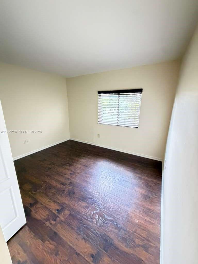 12625 Southwest 91st Street, Unit 209 Miami, FL 33186 - Photo 11 of 17 an empty room with wooden floor and windows