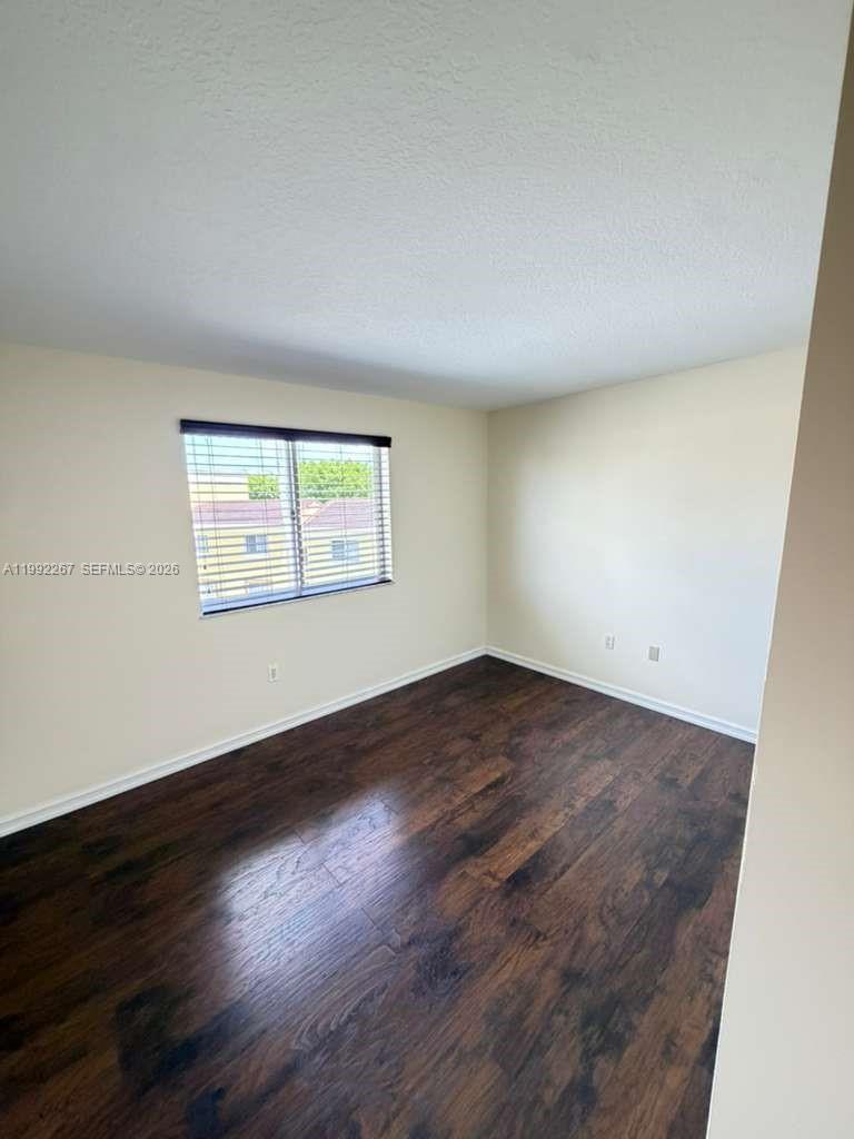 12625 Southwest 91st Street, Unit 209 Miami, FL 33186 - Photo 13 of 17 an empty room with wooden floor and windows