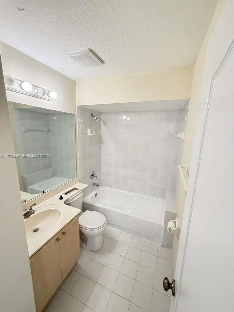 12625 Southwest 91st Street, Unit 209 Miami, FL 33186 - Photo 16 of 17 a bathroom with a granite countertop sink a toilet and shower