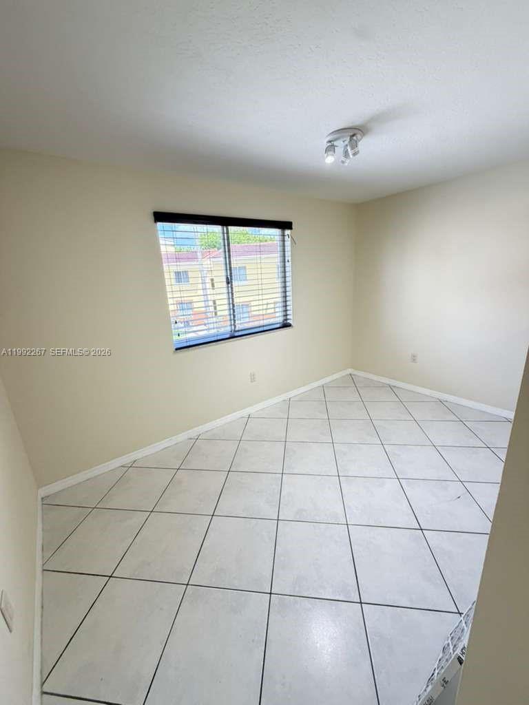 12625 Southwest 91st Street, Unit 209 Miami, FL 33186 - Photo 3 of 17 a view of an empty room and window
