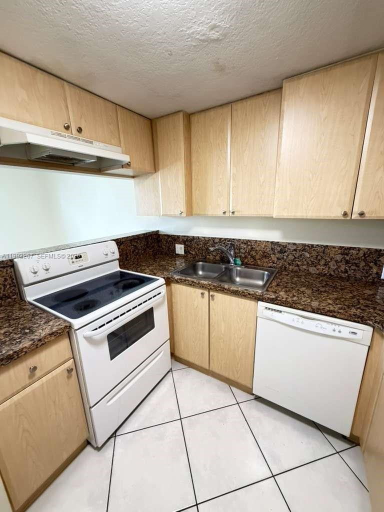 12625 Southwest 91st Street, Unit 209 Miami, FL 33186 - Photo 6 of 17 a kitchen with a stove and a refrigerator