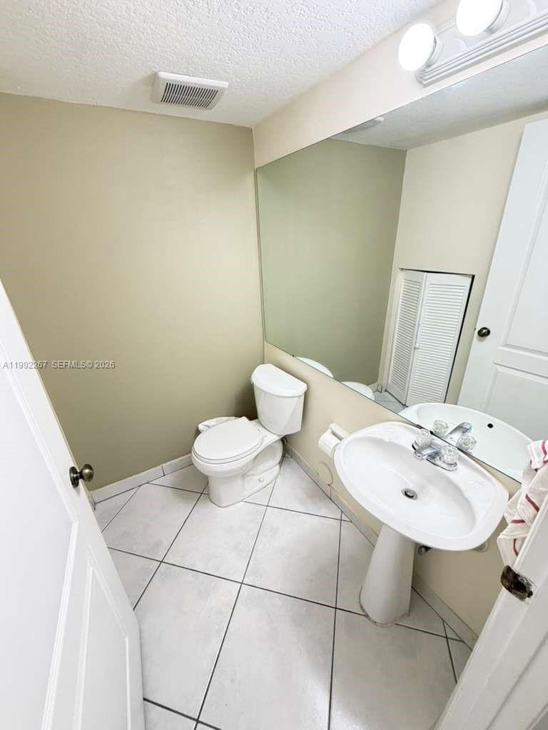 12625 Southwest 91st Street, Unit 209 Miami, FL 33186 - Photo 9 of 17 a bathroom with a sink mirror and toilet