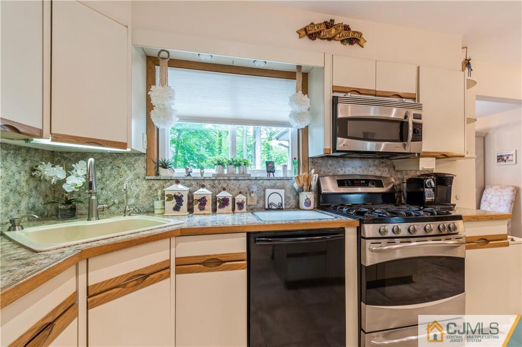 18 Frances Road Edison, NJ 08820 - Photo 8 of 29 a kitchen with stainless steel appliances a stove a sink and a microwave