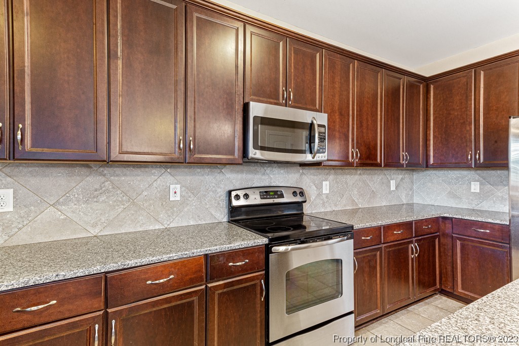 30 Appomattox Drive Cameron, NC 28326 - Photo 13 of 33 a kitchen with granite countertop wooden cabinets and stainless steel appliances