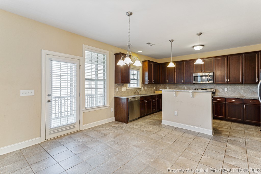 30 Appomattox Drive Cameron, NC 28326 - Photo 10 of 33 a large kitchen with granite countertop a stove a sink dishwasher a refrigerator and a oven with wooden cabinets