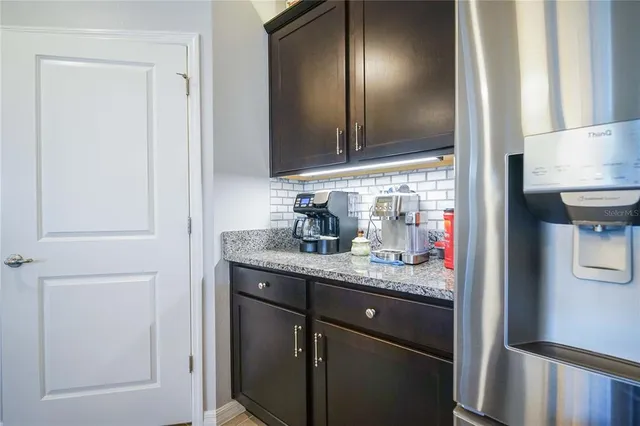 a living room with furniture a flat screen tv and kitchen view