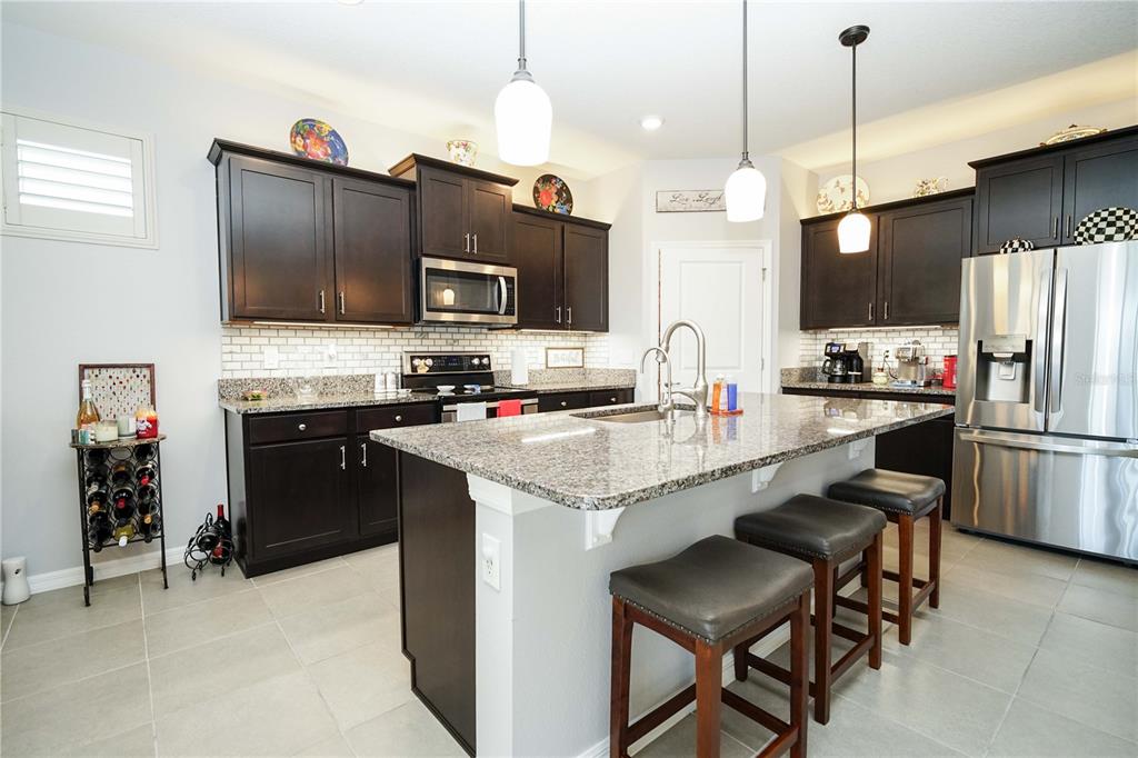 6250 Southwest 89th Ln Road Ocala, FL 34476 - Photo 36 of 71 a kitchen with kitchen island a sink stove and refrigerator