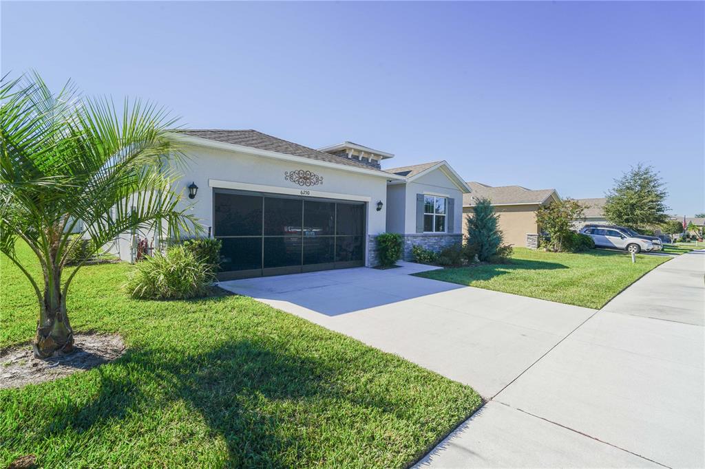 6250 Southwest 89th Ln Road Ocala, FL 34476 - Photo 7 of 71 a front view of a house with a yard and potted plants