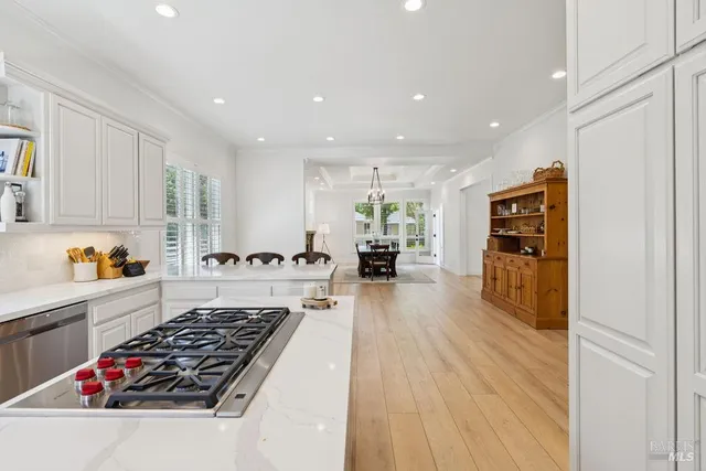 a large kitchen with stainless steel appliances granite countertop a lot of counter space and wooden floor