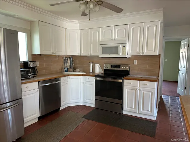 a kitchen with granite countertop a sink stainless steel appliances and cabinets
