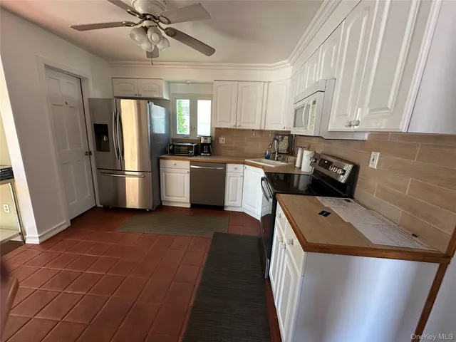 a kitchen with stainless steel appliances granite countertop a refrigerator a stove a sink and dishwasher