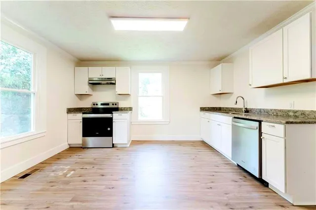 a kitchen with granite countertop a stove top oven and sink