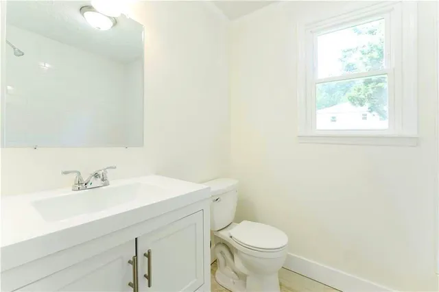 a bathroom with a sink a toilet and a mirror