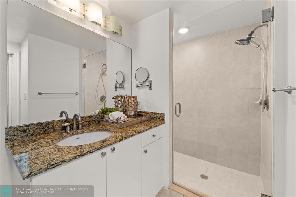 1830 Radius Drive, Unit 605 Hollywood, FL 33020 - Photo 13 of 38 a bathroom with a granite countertop sink a mirror and shower