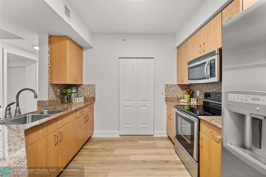 1830 Radius Drive, Unit 605 Hollywood, FL 33020 - Photo 7 of 38 a kitchen with stainless steel appliances granite countertop a stove a sink dishwasher and a refrigerator