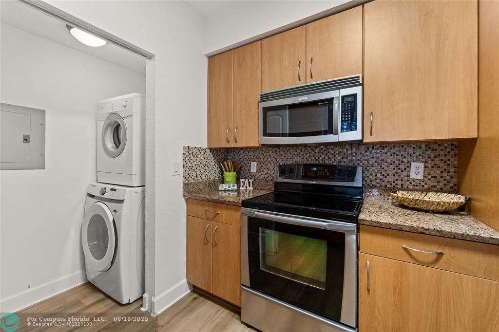 1830 Radius Drive, Unit 605 Hollywood, FL 33020 - Photo 8 of 38 a kitchen with granite countertop cabinets washer and dryer