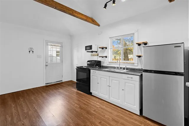 a view of a room with wooden floor and a ceiling fan