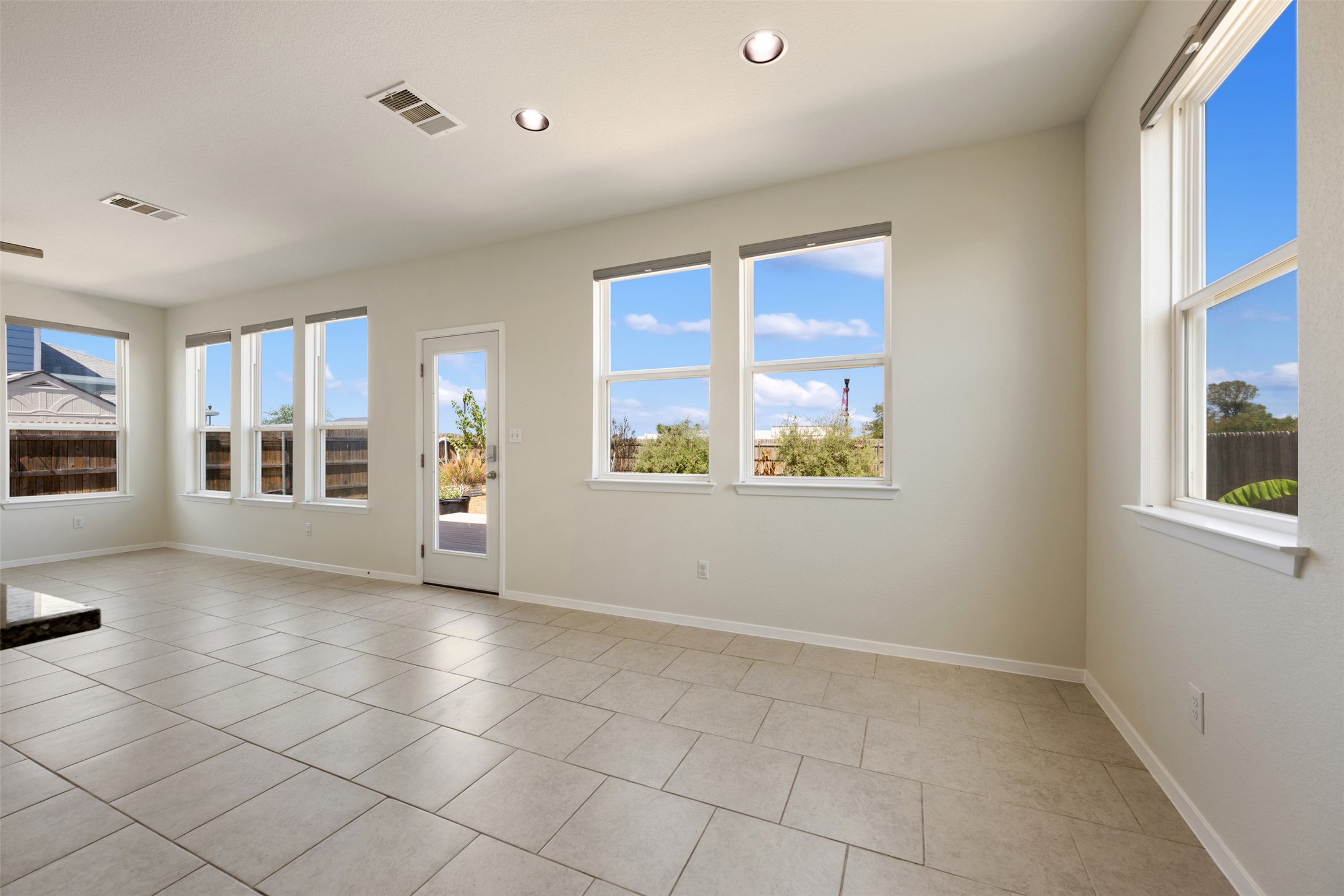 104 Cates Cove Elgin, TX 78621 - Photo 13 of 31 Numerous windows and tile flooring define this airy living space opening to the backyard.