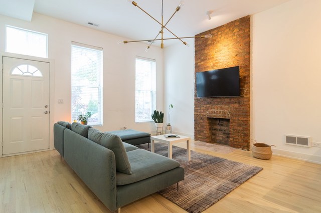 2441 West Harrison Street, Unit 1 Chicago, IL 60612 - Photo 2 of 10 a living room with furniture a fireplace and a flat screen tv