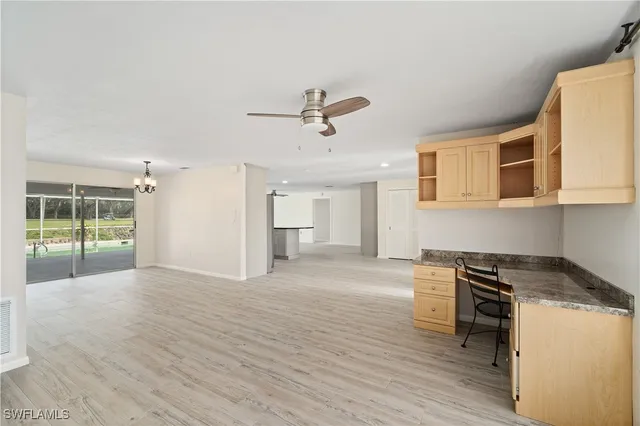a view of a kitchen with wooden floor and a ceiling fan