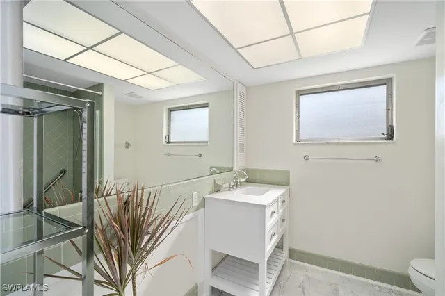 a bathroom with a sink a mirror and a toilet